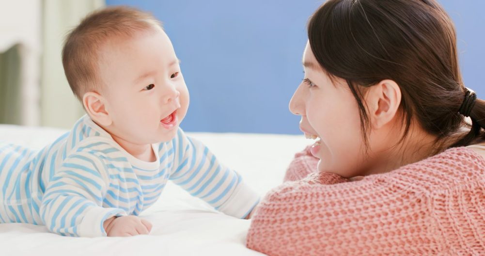 Cute baby boy babbling with mom.