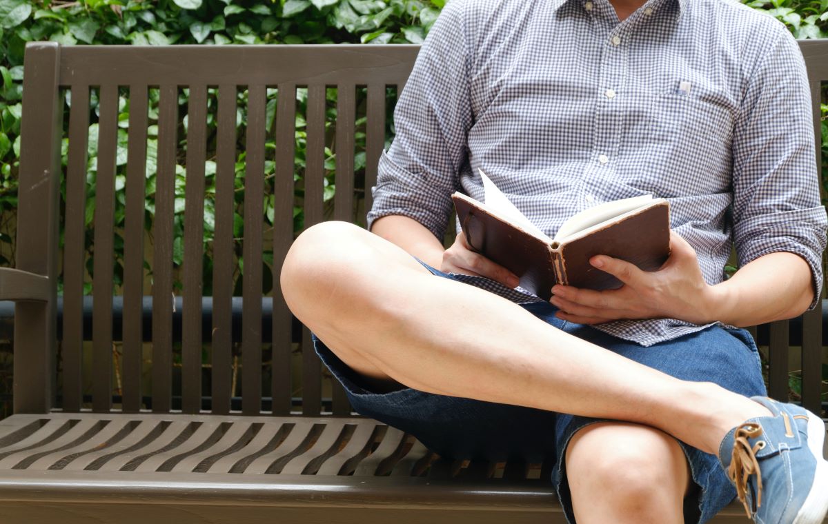 Dad reading a book on a bench on Father's Day