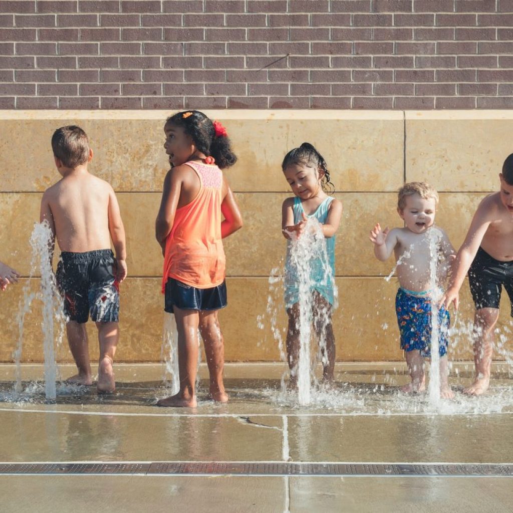 Kids playing outside at a splash pad