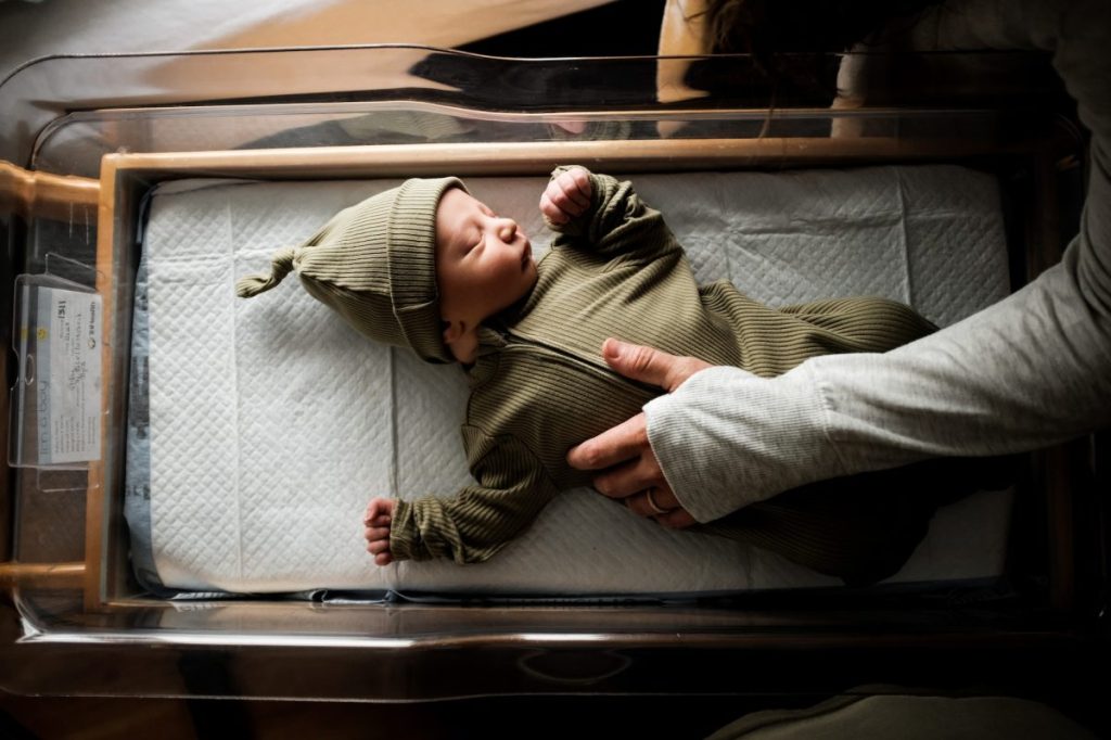 A newborn baby in a bassinet