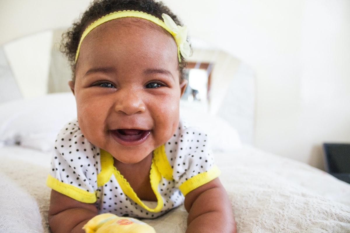 A baby on her tummy laughing