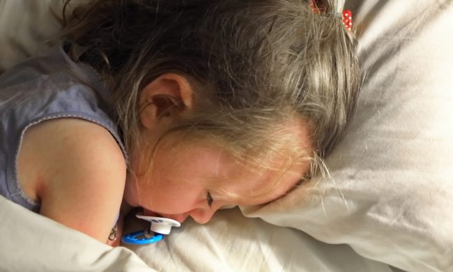 A toddler sleeping in the bed