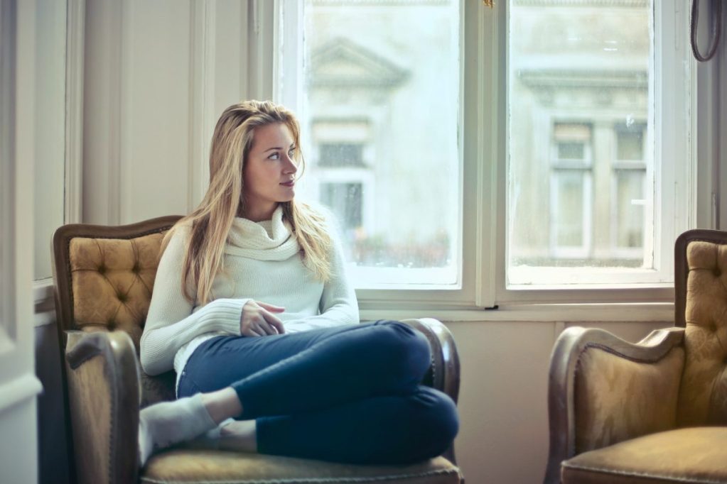 A woman in a chair looking out of the window.