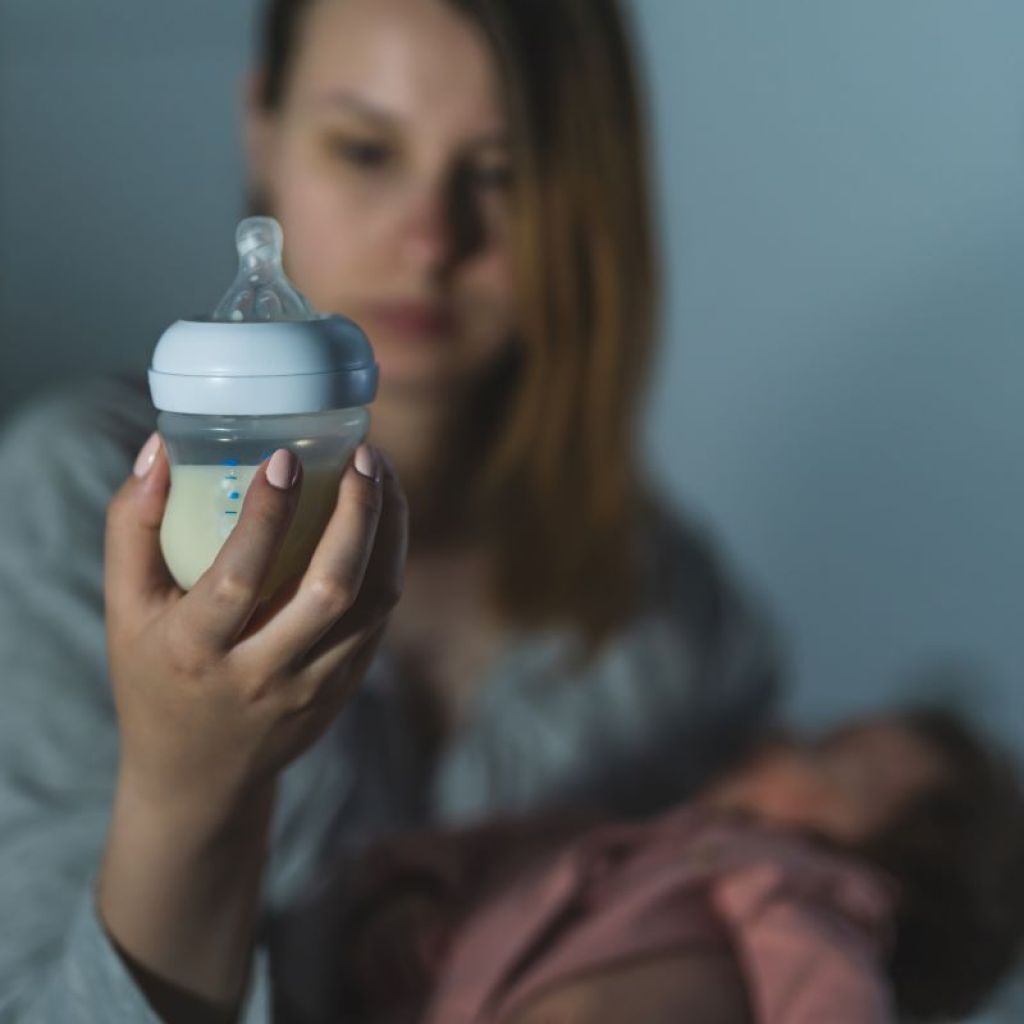 Mom looking at bottle to see if baby drank enough