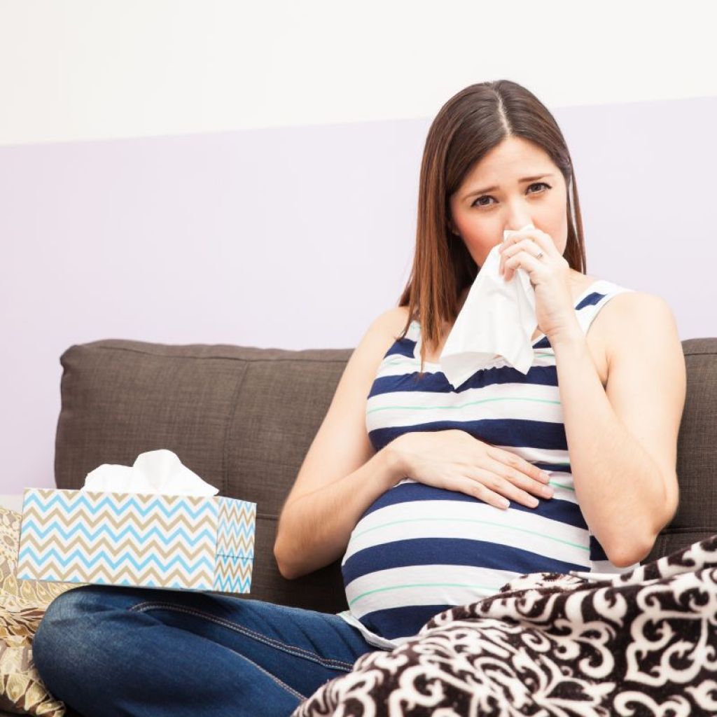 Pregnant woman on the couch with a cold