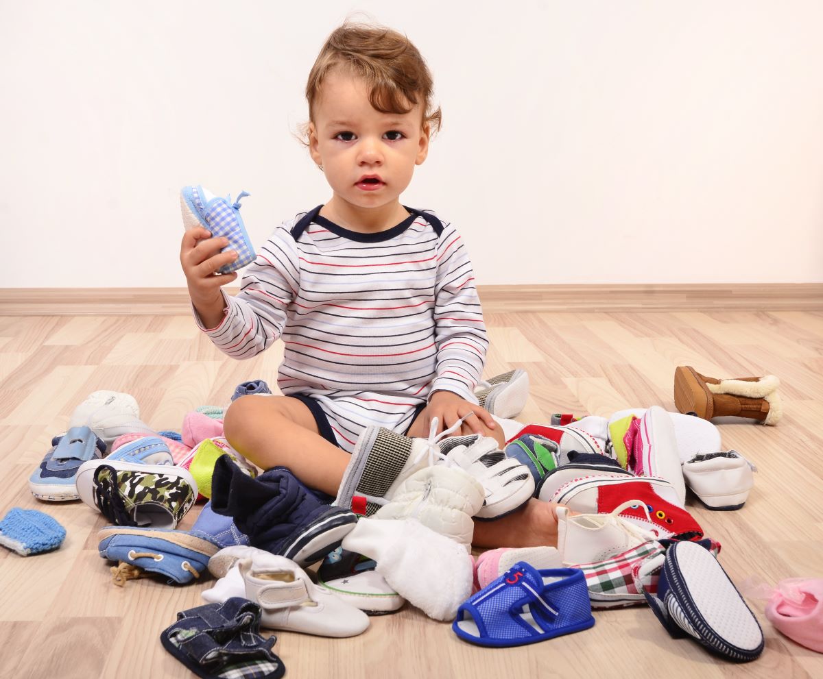 baby sitting in a pile of baby shoes