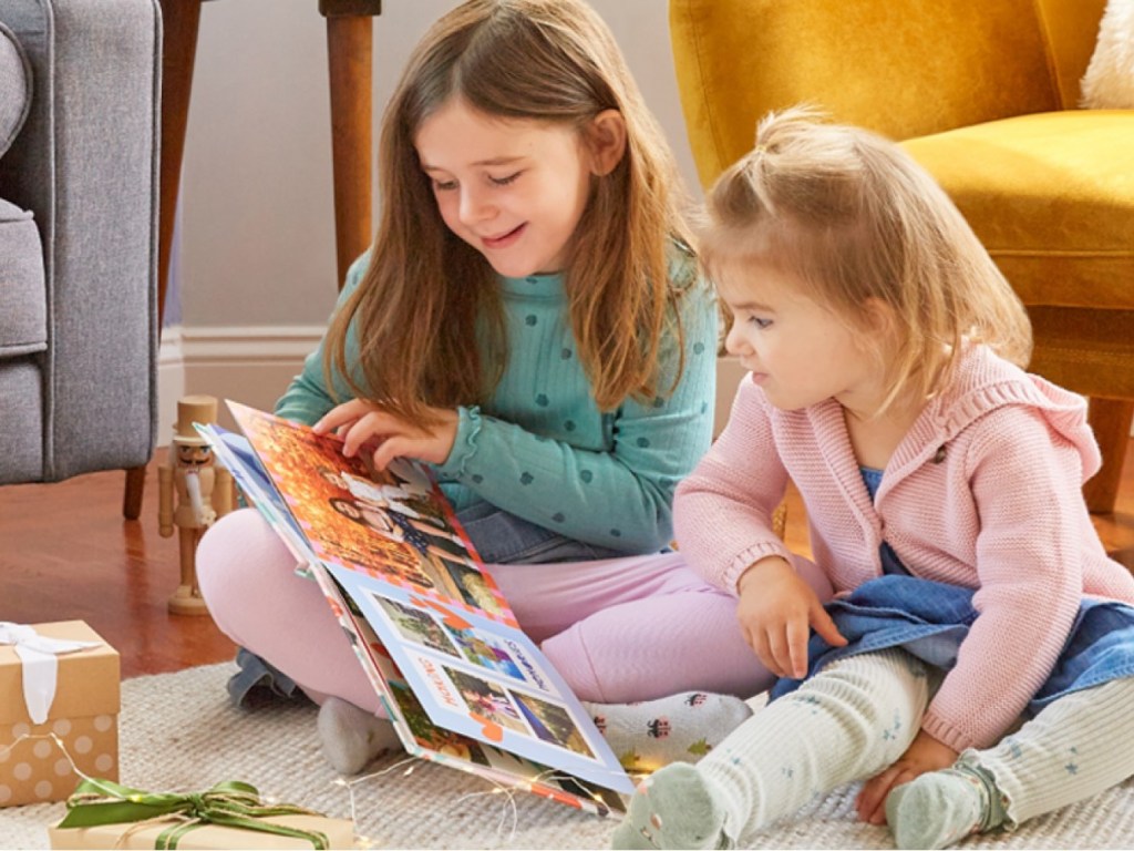 Sisters looking at Mixbook photo book and baby pics.