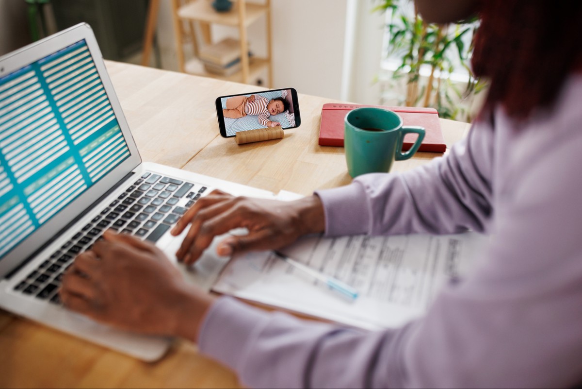 Mother using a baby monitor to check on her son while working from home
