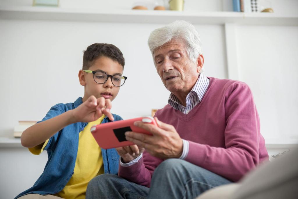 Grandpa with grandson a device together