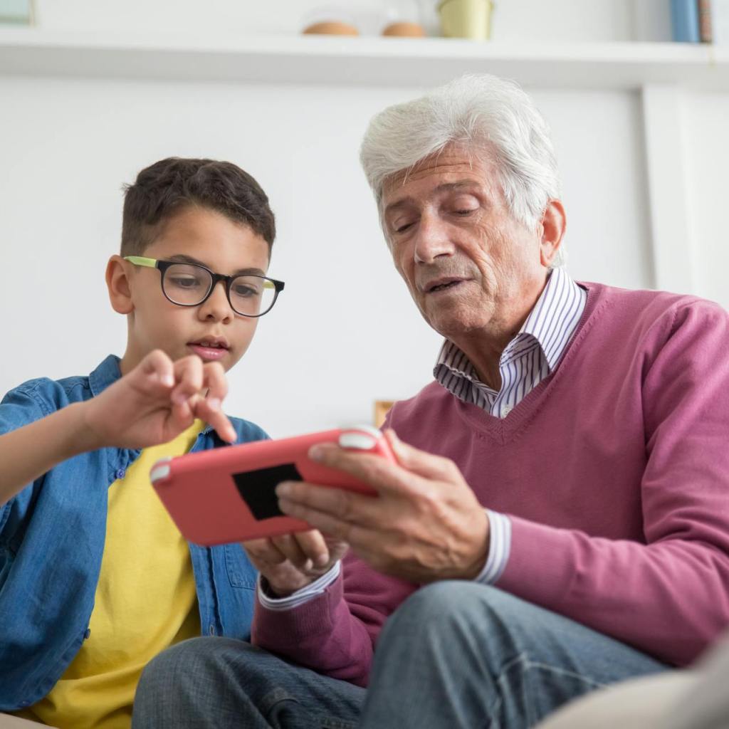 Grandpa with grandson a device together