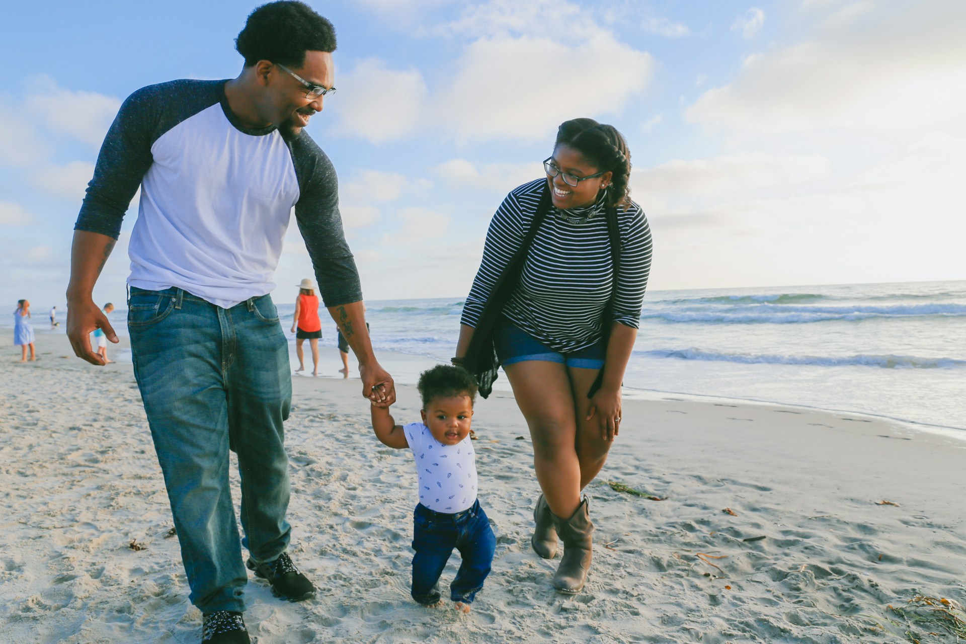 family with their toddler on the beach