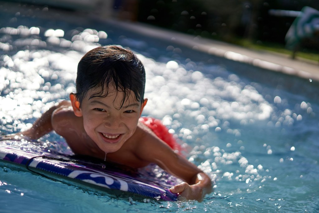 A child in the water on a water board.