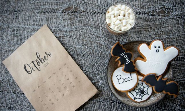 Bowl of Halloween treats next to October written of a piece of paper
