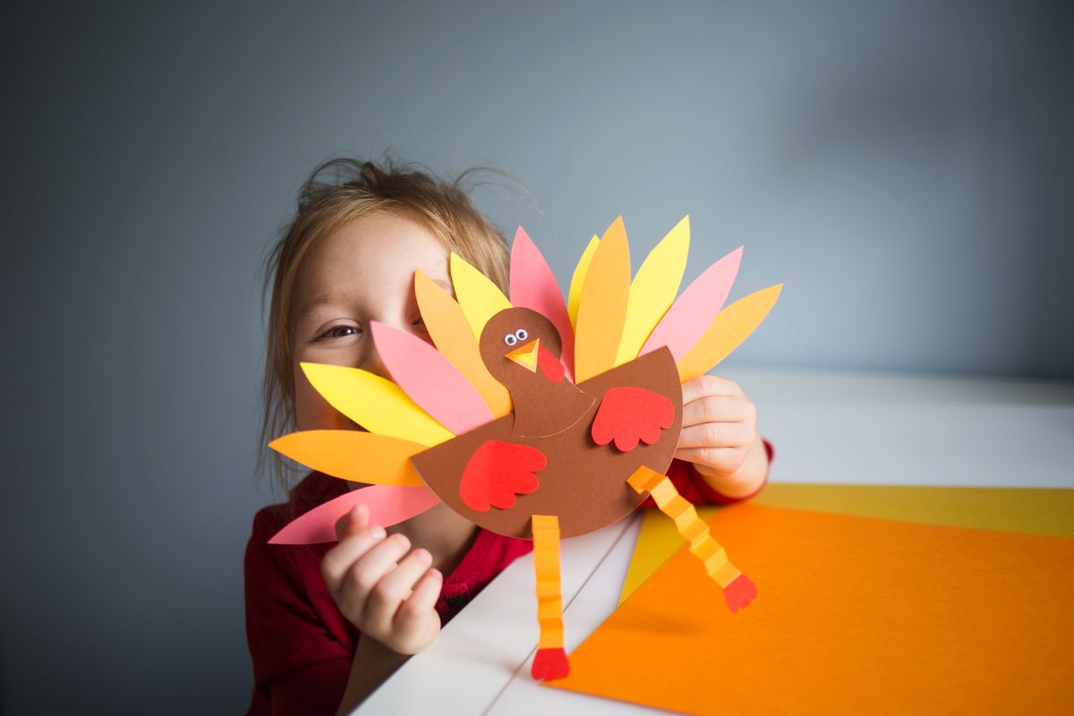 Little girl showing off her Thanksgiving turkey craft