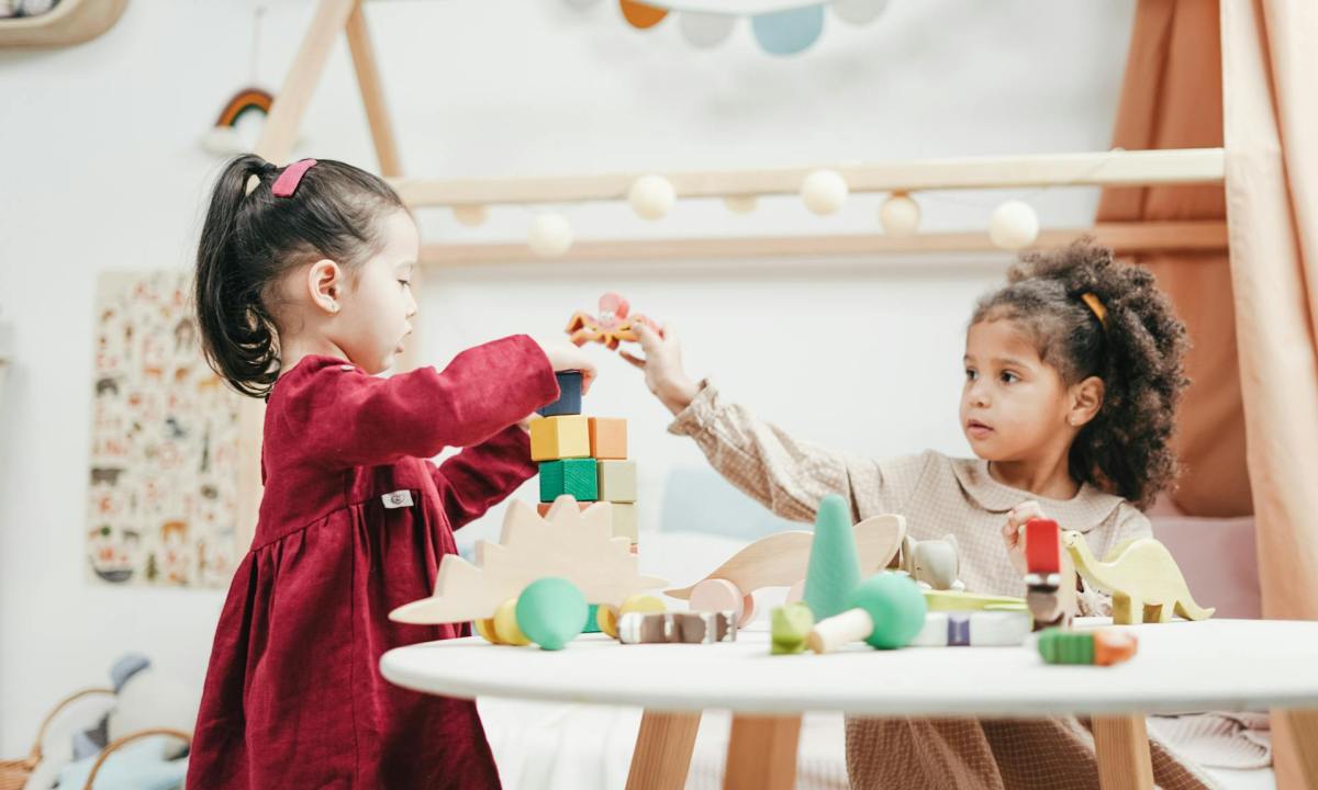 two small girls playing with wooden toys