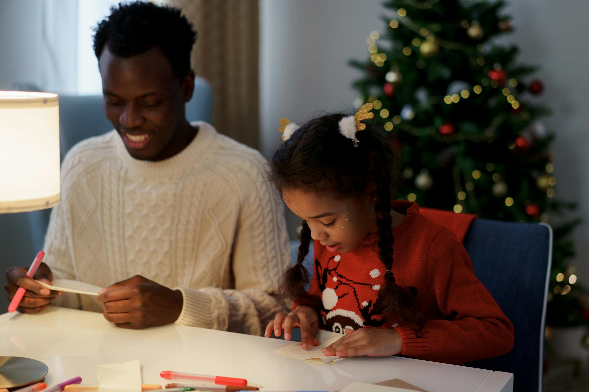 A father and daughter making Christmas crafts.