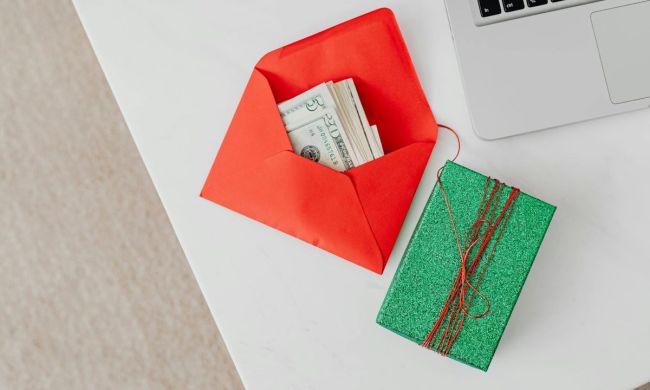Money in an envelope with a small gift box