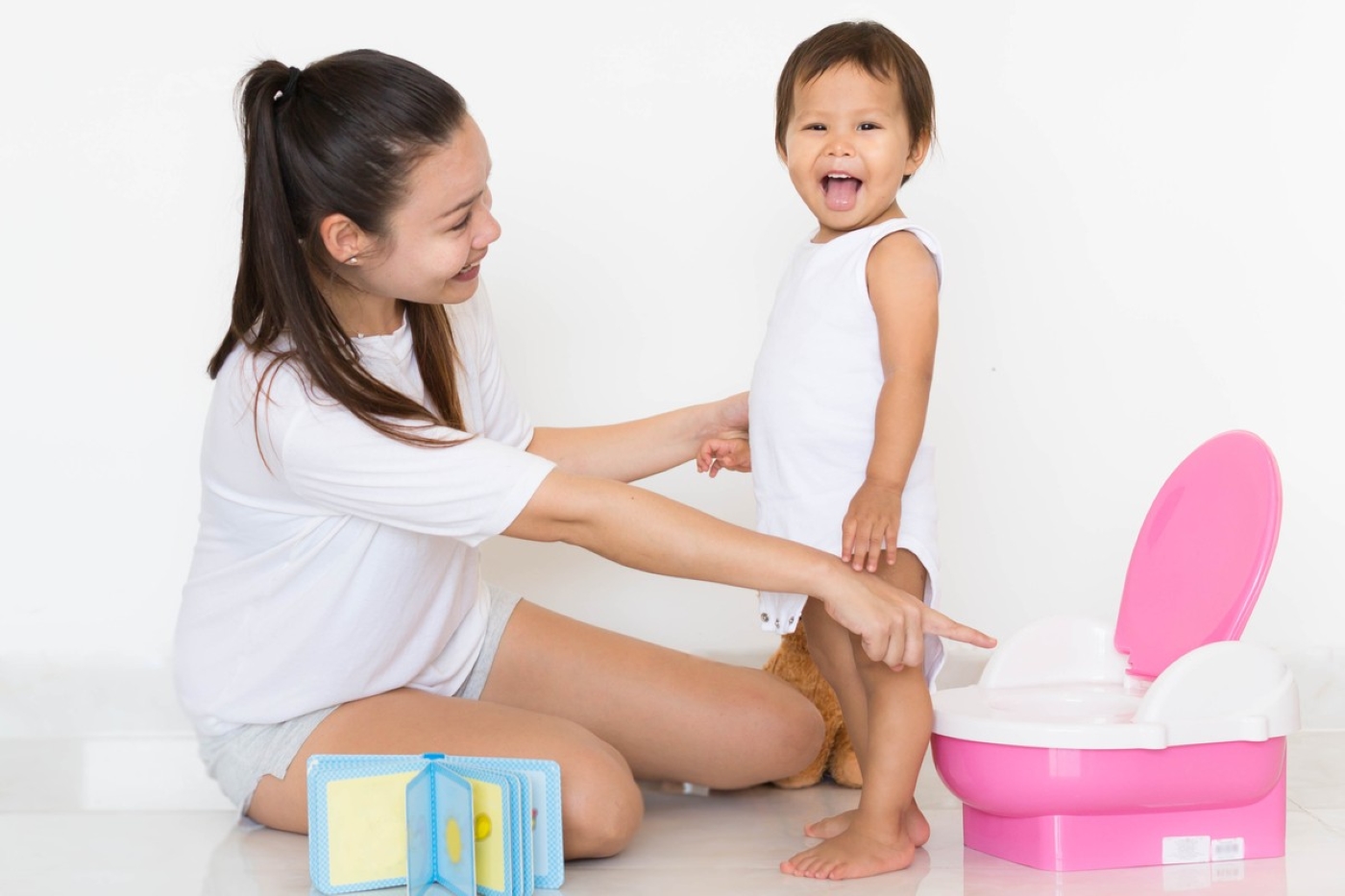 A mother helping her toddler on the potty