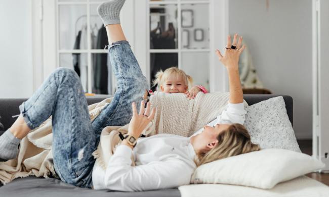 Parent on the couch playing with a child