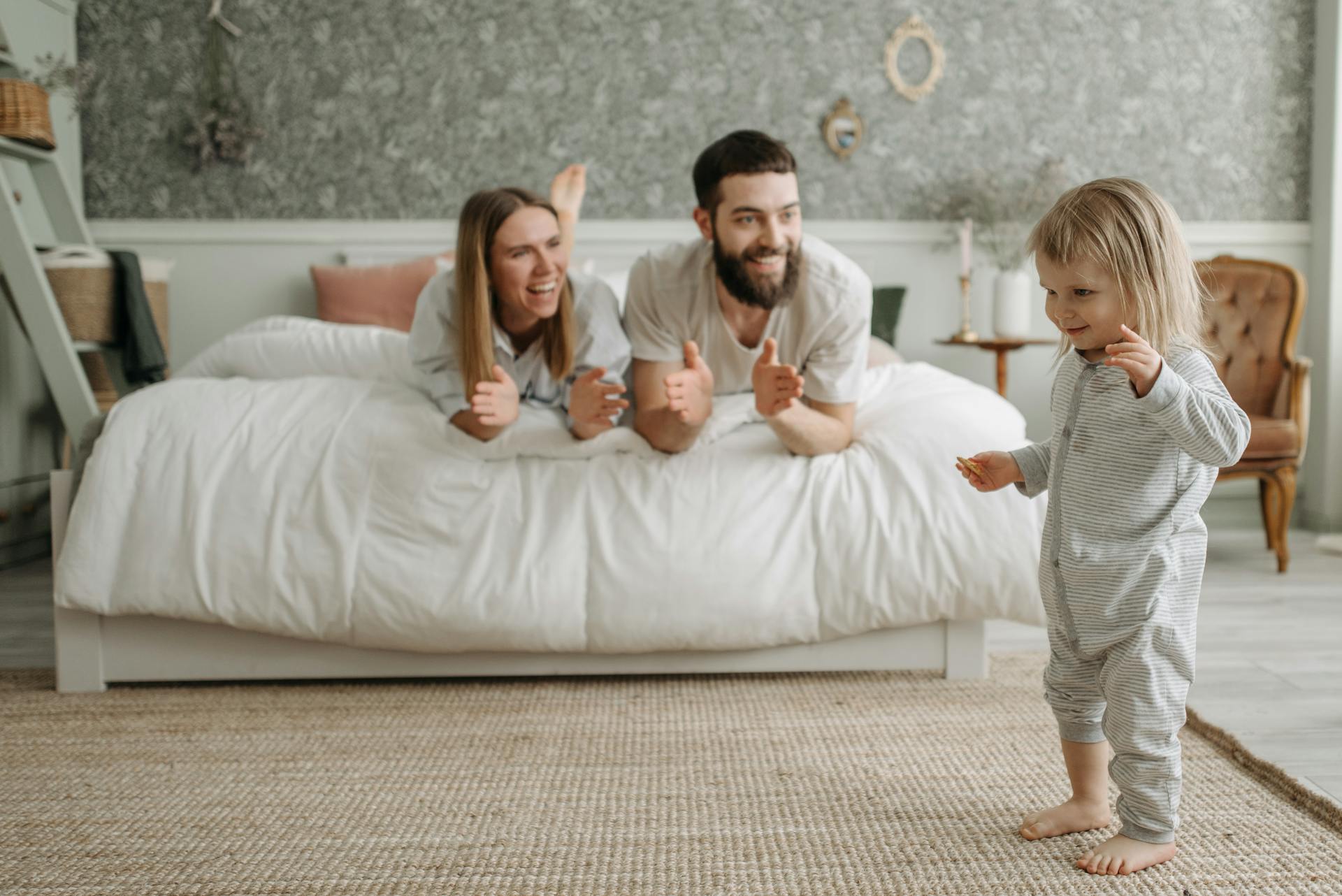 Parents on the bed with child playing.