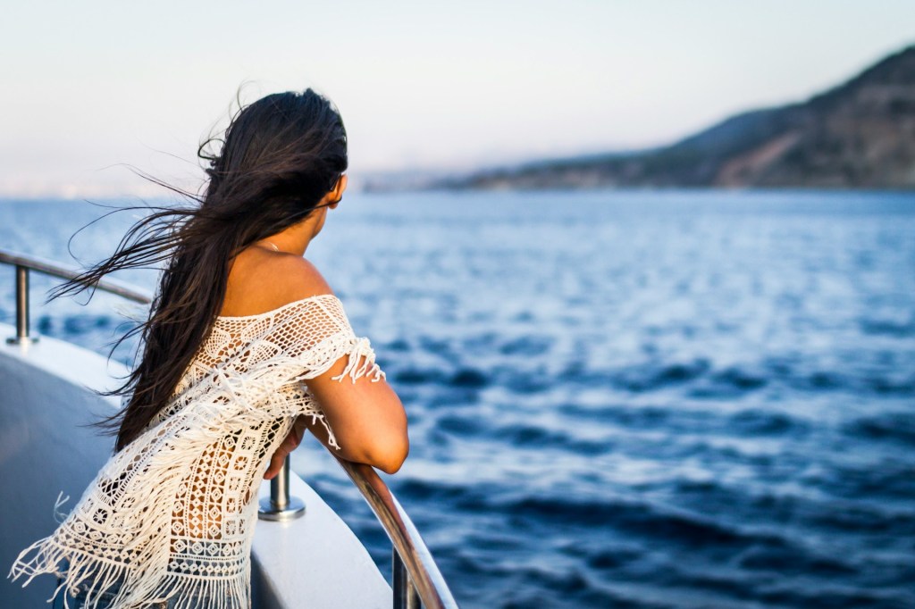 A female looking over the side of a cruise ship.