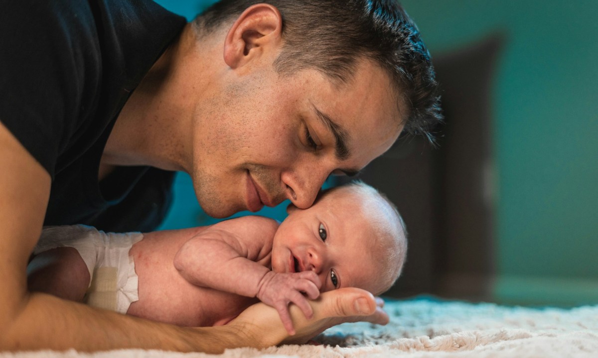 A dad holding his newborn child.