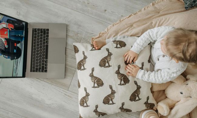 Cute toddler watching a movie on a laptop