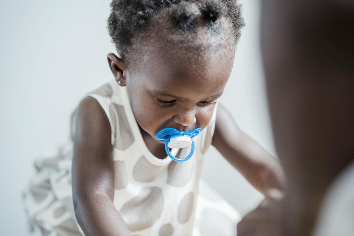toddler with pierced ears playing