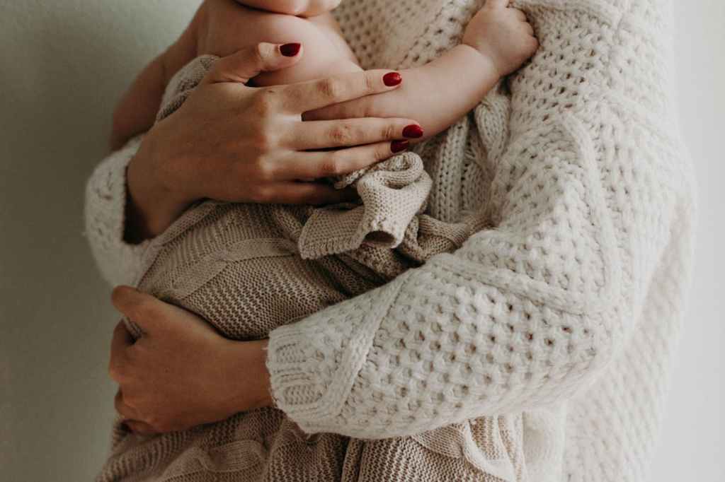 mom holding baby knit blanket