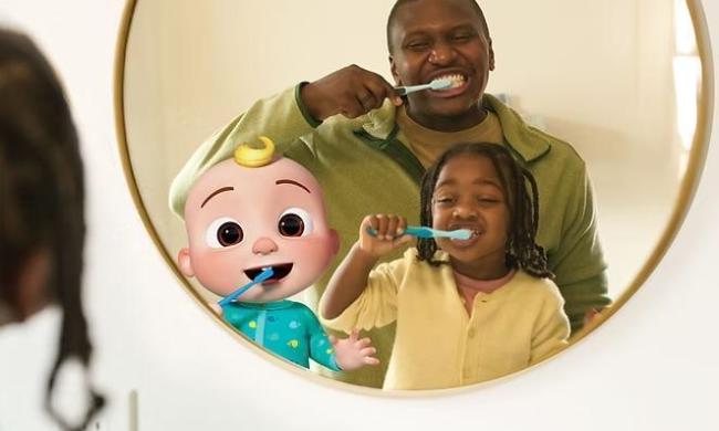 Dad brushing teeth with daughter and looking in the mirror with CoComelon