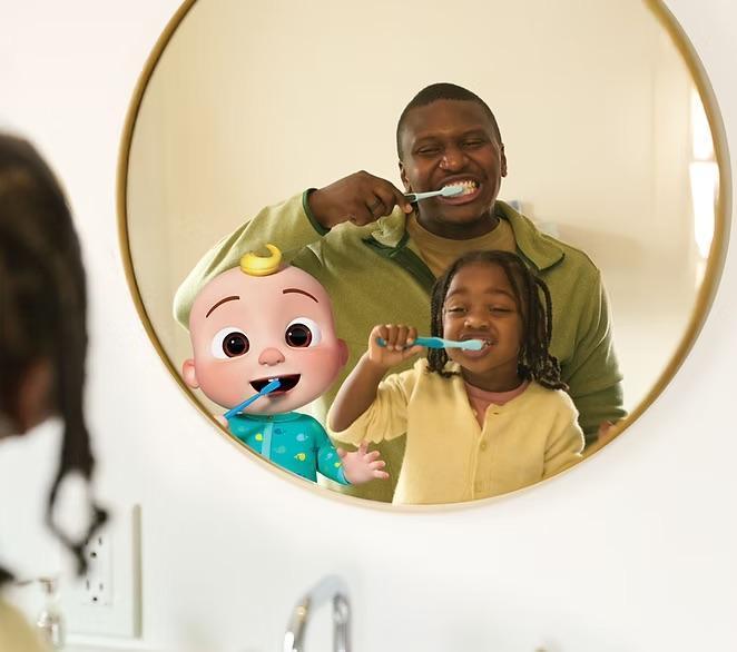 Dad brushing teeth with daughter and looking in the mirror with CoComelon